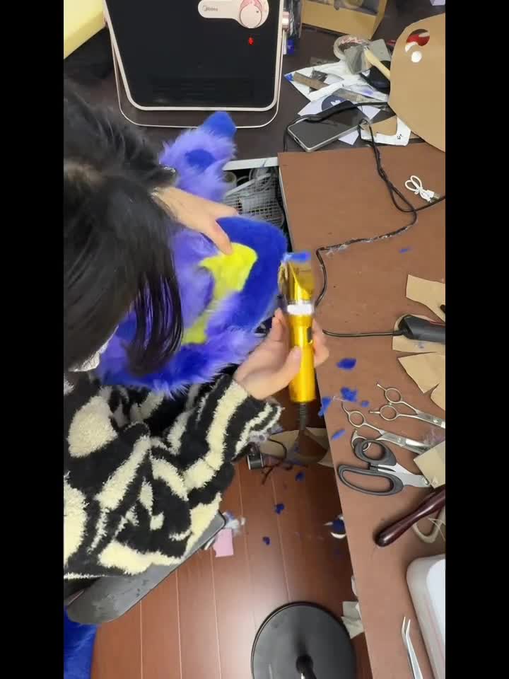 Hand trimming fur during a WildSoul Studio fursuit build